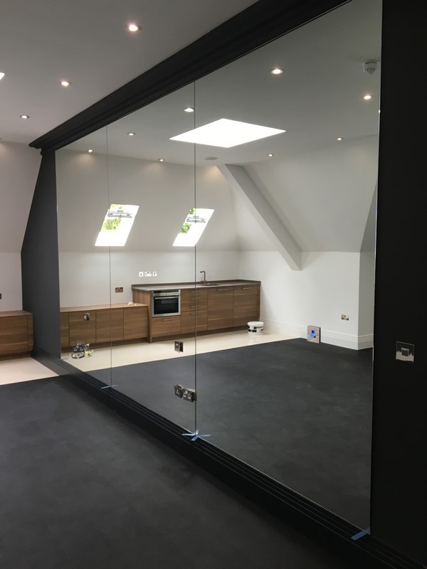 Frameless glass partition in loft conversion by Forest Hill glaziers